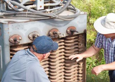 Two men are looking at a large piece of metal.