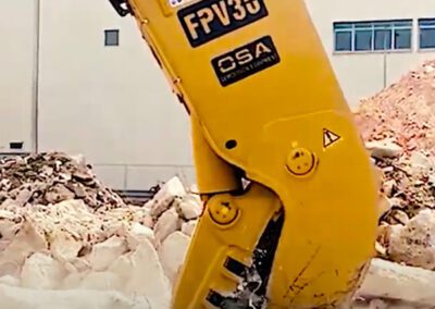 A yellow machine is on the ground with rubble